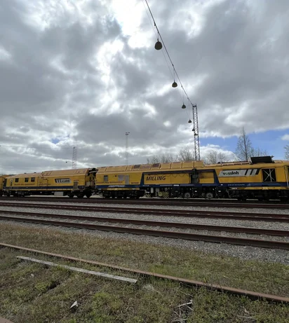Milling train SF03 on tracks, cloudy sky