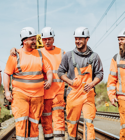 5 employees running along the tracks